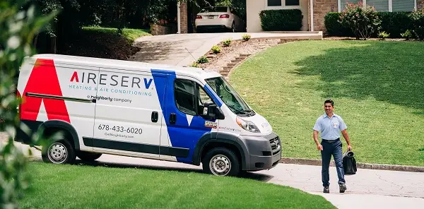 Aire Serv HVAC service technician walking up to a home to perform repairs.