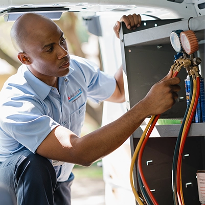 An Aire Serv technician working with gauges.