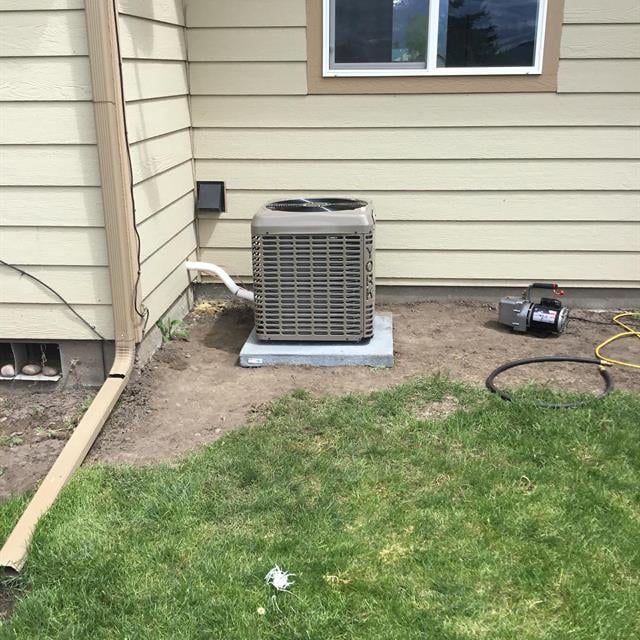 AC unit and grass lawn next to house