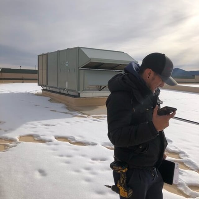 Aire Serv Employee on a roof in the snow