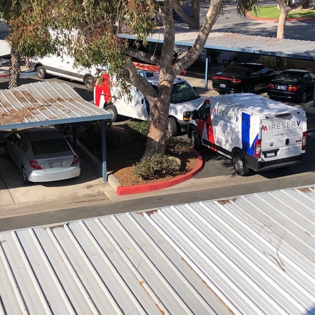 Aire Serv Vans Parked Outside of Building