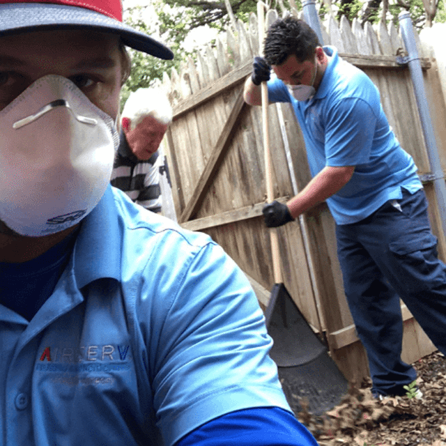 Aire Serv pros raking and working near fence line