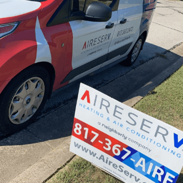 Aire Serv van parked next to curb with Aire Serv sign