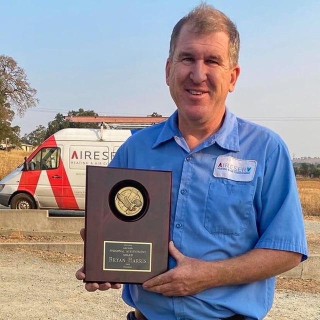 Bryan Harris holding the Personal Achievement Award.