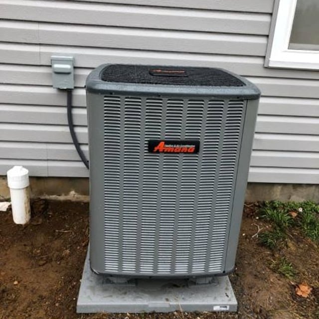 Amana AC condenser mounted on concrete slab