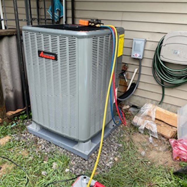 Amana AC condenser on plastic platform being tested for AC tune-up.