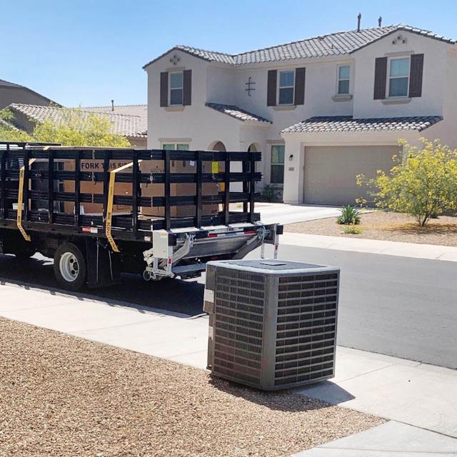 A new air conditioning unit on the sidewalk next to a truck