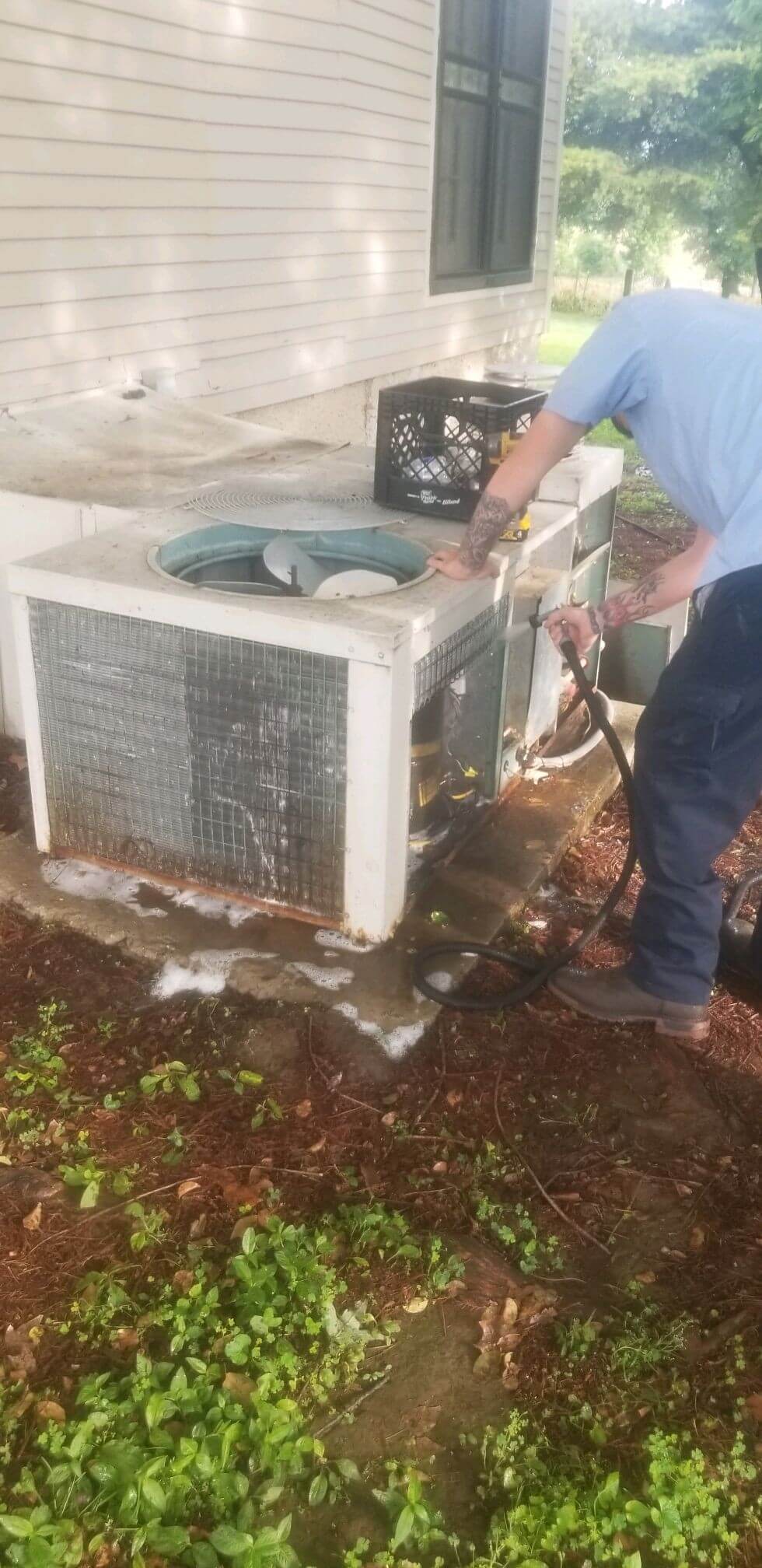 Professional expert cleaning an A/C unit during a tune up.