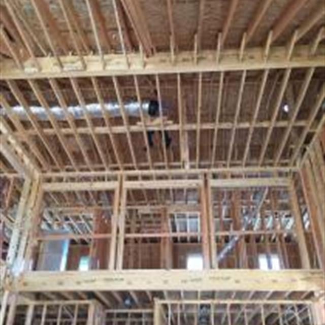 Aire Serv technician Don installing duct in rafters of new construction project.