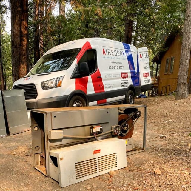 Aire Serv van behind a unit in a wooded area