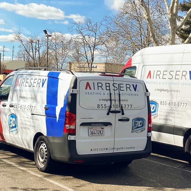 Two Aire Serv Vans in a parking lot