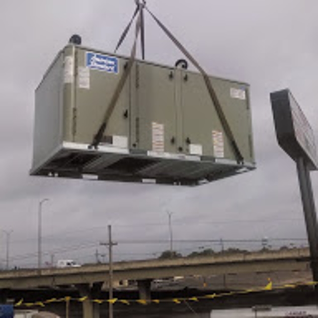 HVAC unit being held up by crane