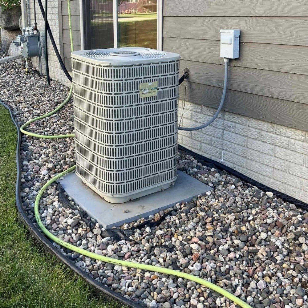 Heat Pump in Gravel Outside House