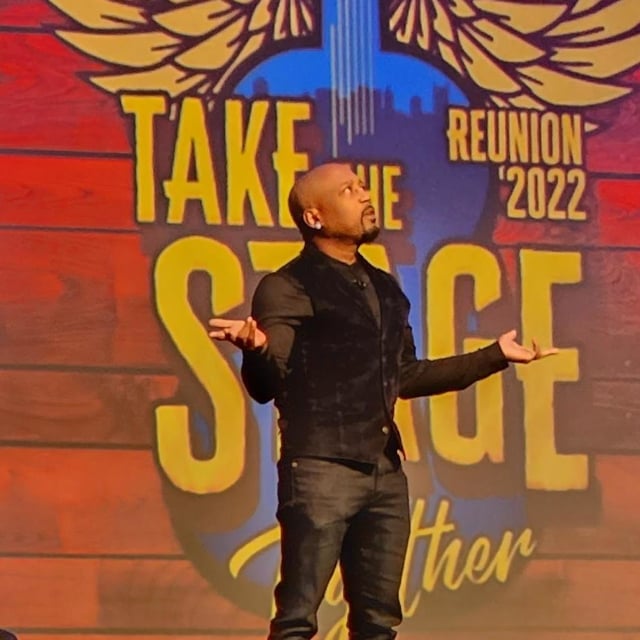 Man standing on take the stage reunion 2022