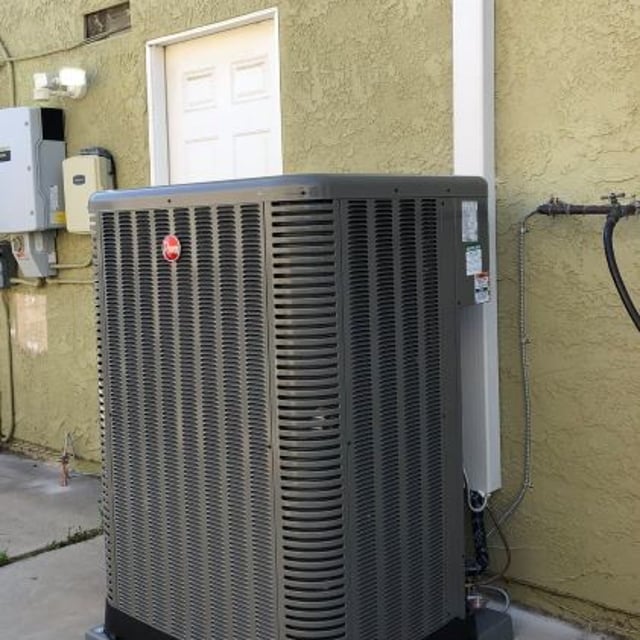 New 16 seer AC condenser installed outside of tan colored home