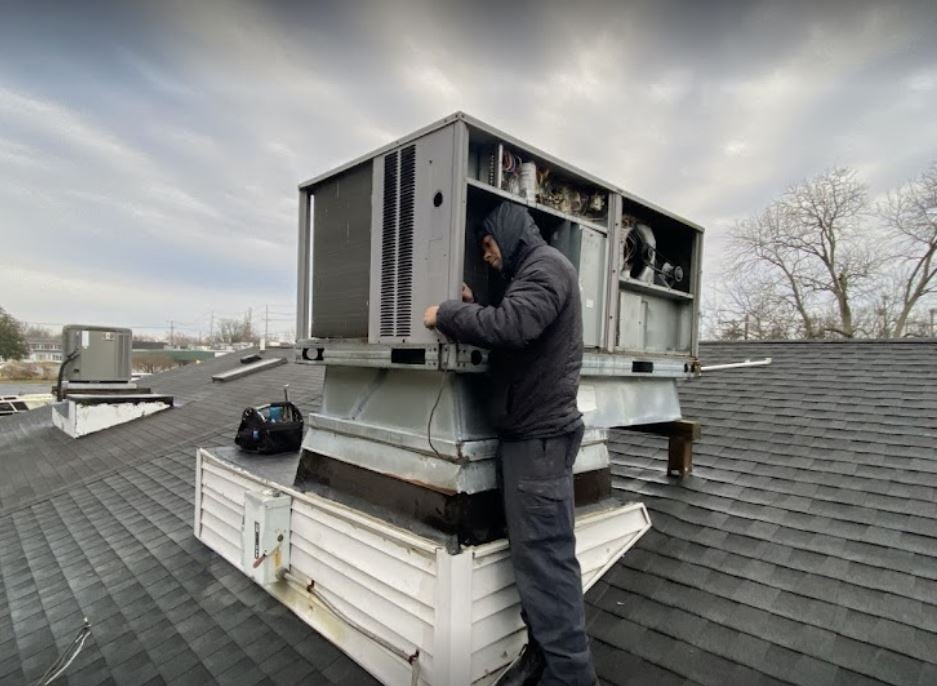 Repairing an AC unit on a rooftop.