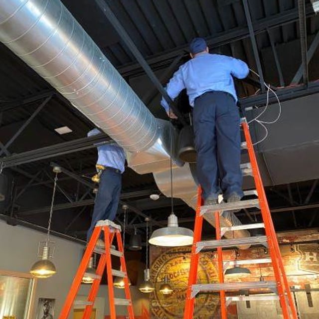 Technicians working on ductwork installation