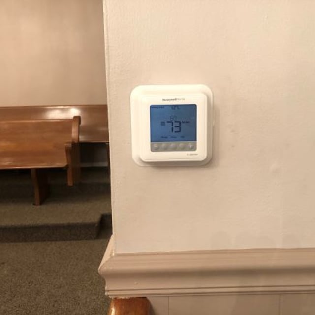 Thermostat installed inside church building on wall