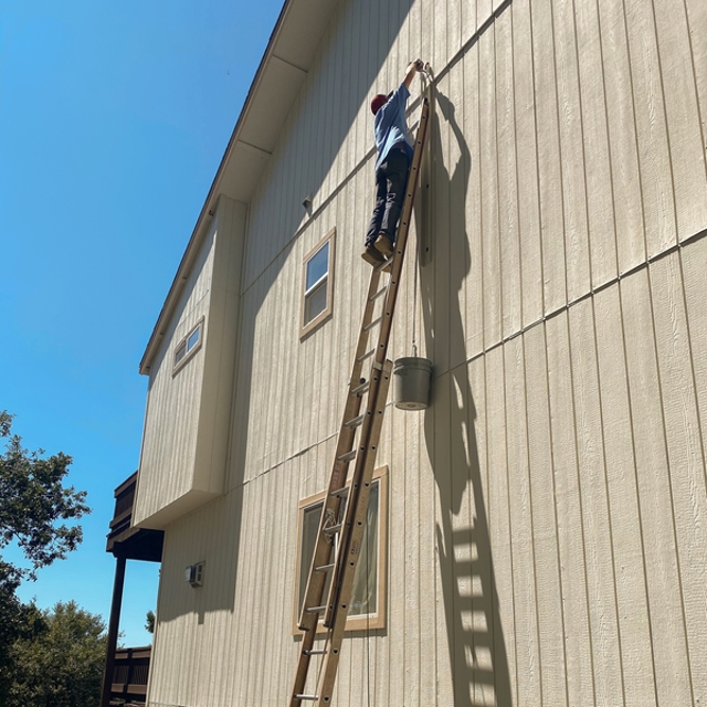 Person on a ladder doing HVAC services.