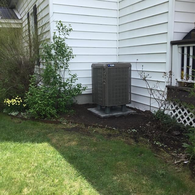 ac unit and grass lawn next to white home