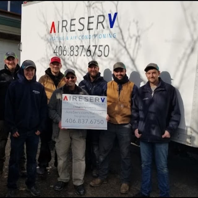 aire serv team members holding an aire serv sign