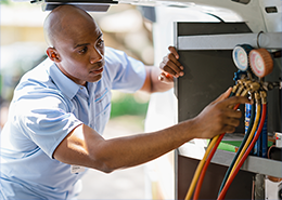 An Aire Serv professional working with a plumbing machine.