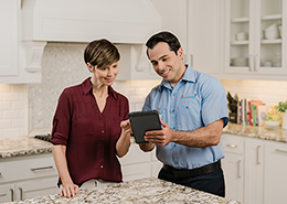 An Aire Serv technician showing a customer something on a tablet.