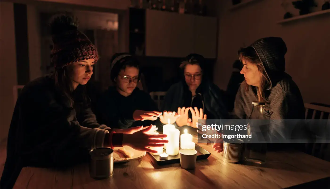 A family gathers around candles after losing power.