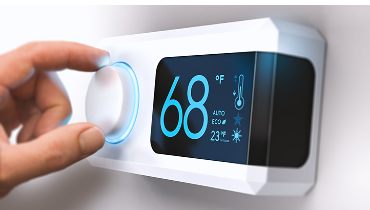 Person adjusting digital thermostat