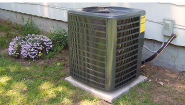 AC condensing unit with label listing specs such as tonnage.