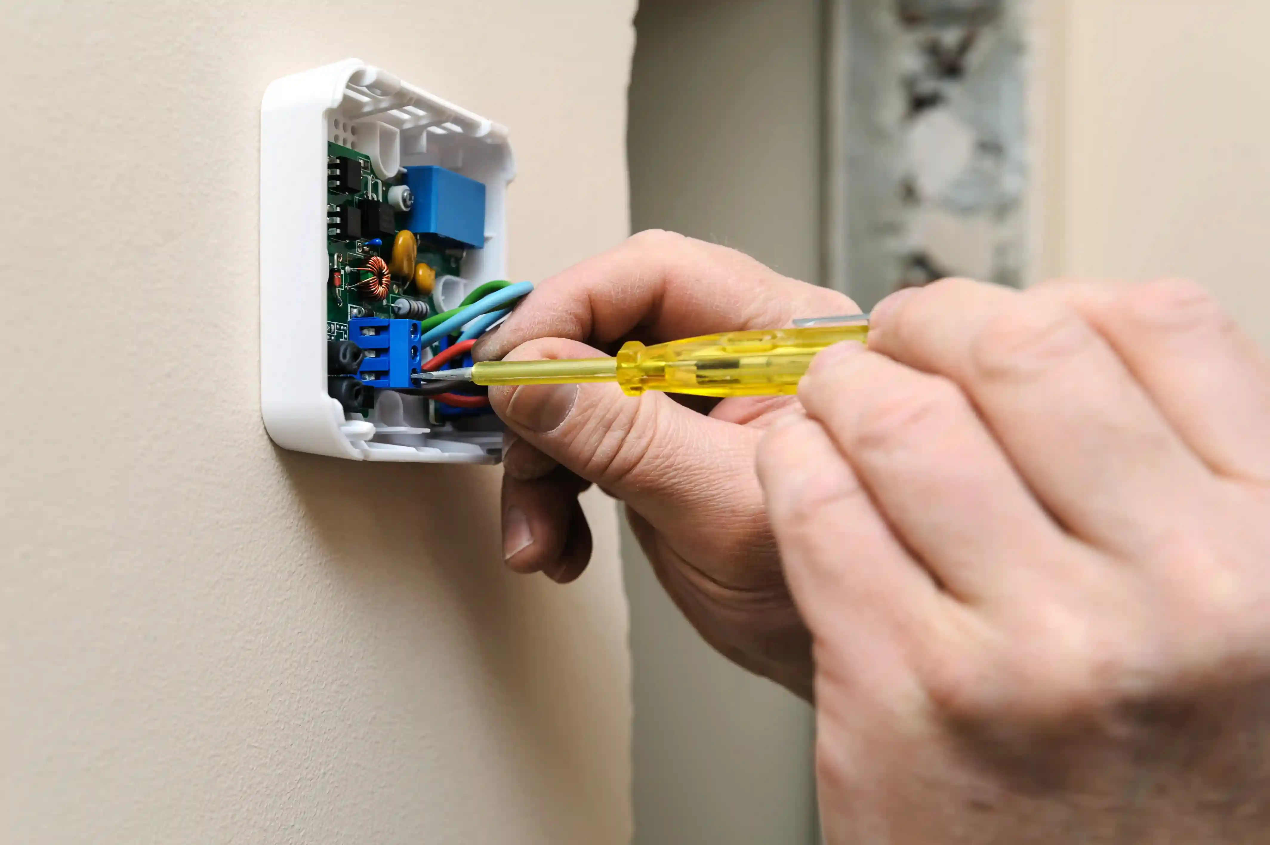 Thermostat with exposed colored wires.