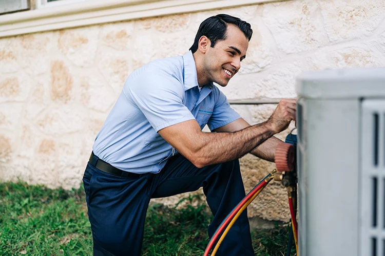 Aire Serv HVAC professional performing maintenance on an outdoor AC unit.